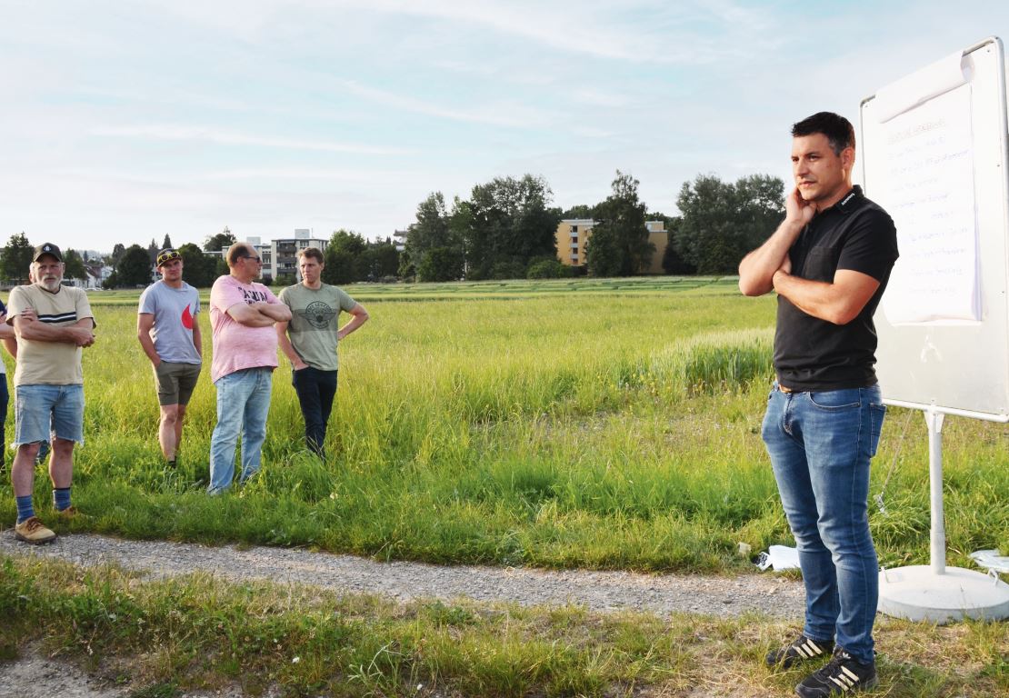 Florian Sandrini (rechts) erörtert die Umsetzung von drei Elementen der BFF auf der offenen Ackerfläche.