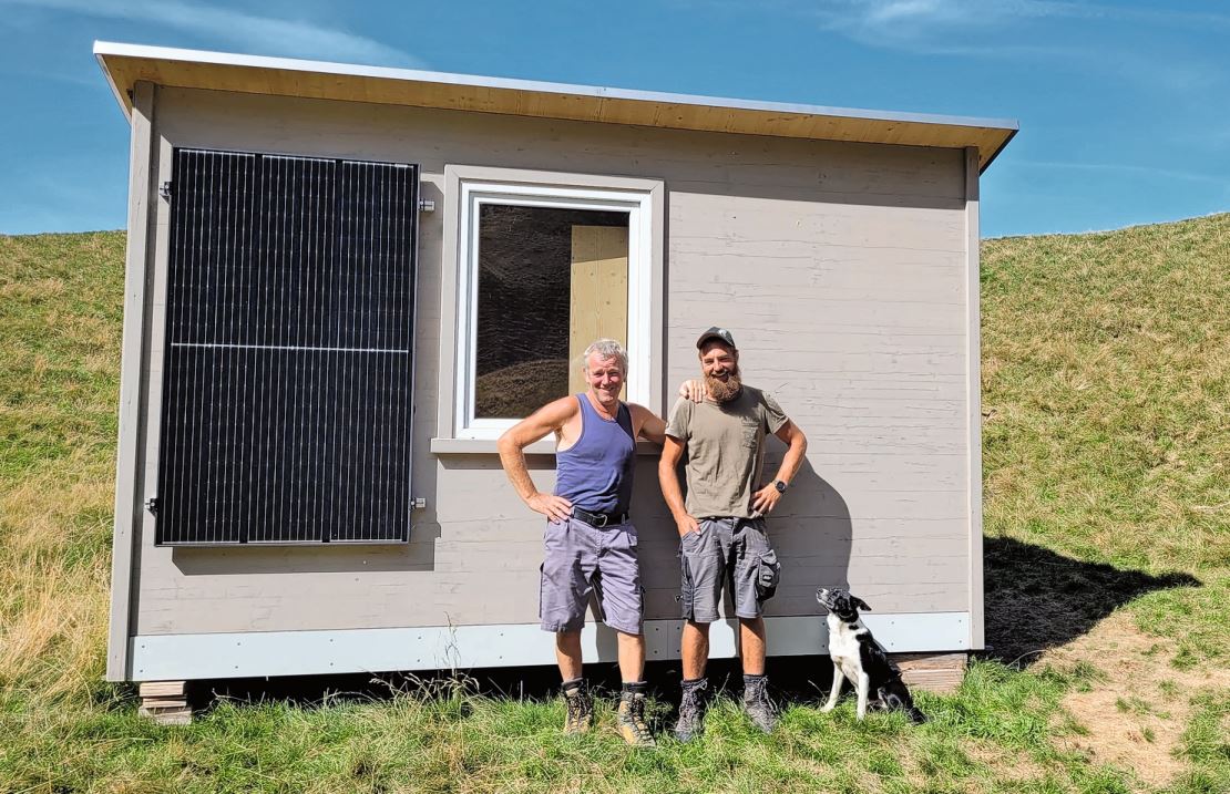 Schafbesitzer Markus Eggenberger (links) und Hirt Daniel Siegenthaler vor der mobilen Hütte, die dem Hirten Unterschlupf bietet.