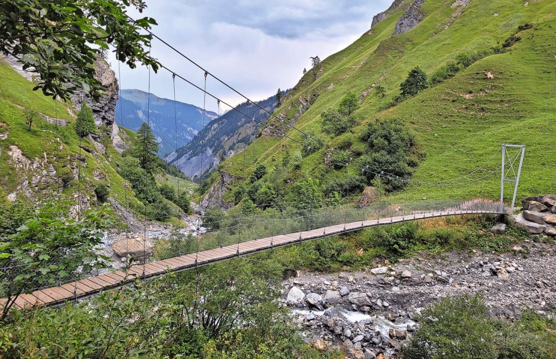 Der Weg auf die Alp ist abenteuerlich. Nach der Querung der wackeligen Hängebrücke geht es steil die Felsen hinauf.