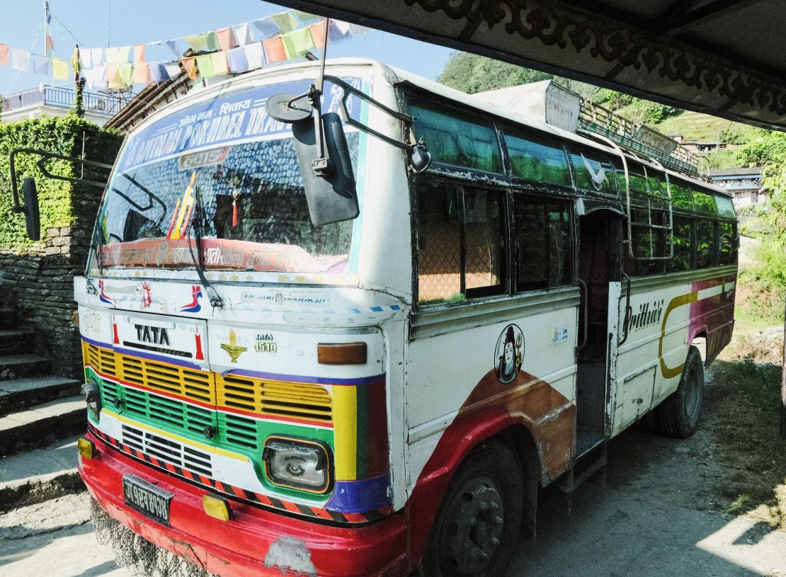 Die öffentlichen Busse sind traditionell farbenfroh auf holprigen Strassen unterwegs.