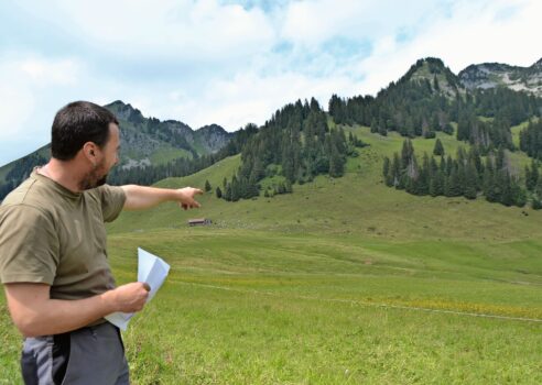 Jürg Roth zeigt von der Strasse her auf die Moorgebiete der Neuenalp.